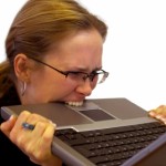 woman biting laptop from stress